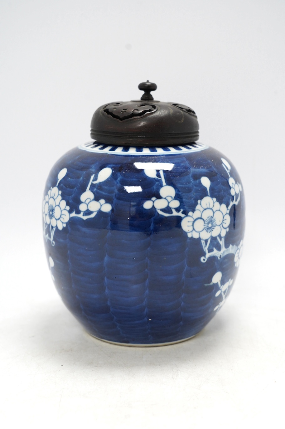 A Chinese blue and white prunus jar, with wood cover, early 20th century, 20.5cm high. Condition - good.